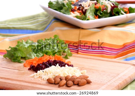 Salad ingredients with salad in the background