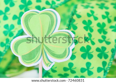 paper shamrock decoration with shamrock ribbon in the background for St. Patrick's Day