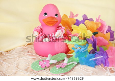 pink rubber duck on sand with beach attire added to the scene (not part of duck)