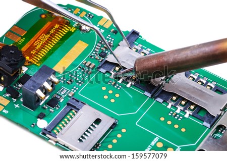 Electronic technician repairs SIM slot on mobile phone circuit board. Close-up with selective focus and Shallow Depth of Field. Isolated on white background.