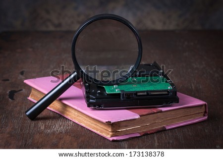 Medical concept, magnifying glass  with computer hdd on wood table