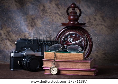 Group of objects on wood table.  wood clock, old watch, retro radio, camera, Still life