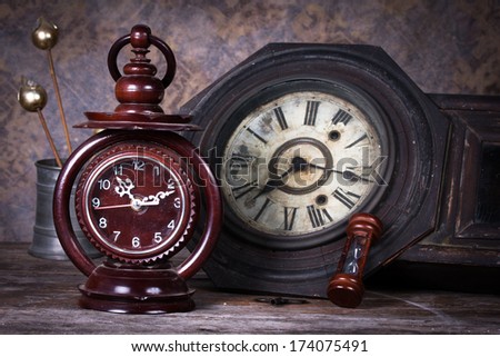 Group of objects on wood table. old clock, hourglass, antique wooden clock ,Still life