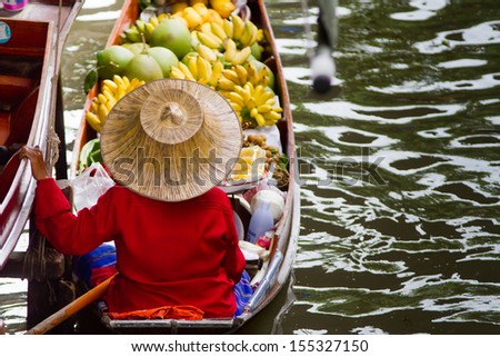 A woman selling fruits at Bangkok floating market.