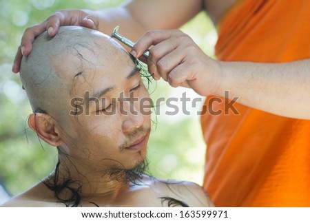 NONTHABURI, THAILAND - APRIL 08 : Thai man gets his head shaved by a monk during a Buddhist ordination ceremony on April 08, 2013 in Nonthaburi, Thailand.