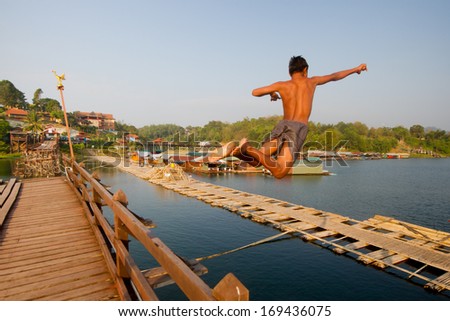 Young boy jumping into river