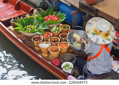 A woman selling Papaya salad Bangkok floating market.