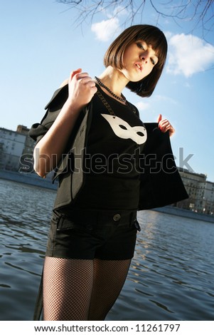Young girl posing in fancy clothes by the river. Moscow city background