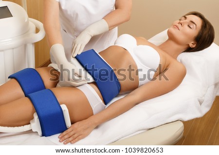 Woman during Cryolipolysis procedure in professional beauty clinic