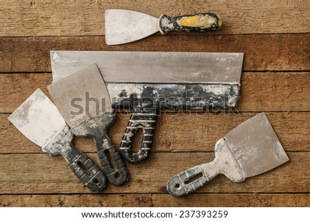 Kit of putty knives over wooden table