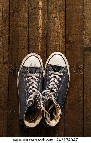 Dirty gym shoes on wooden background