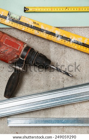 Drill and level tool on dirty floor