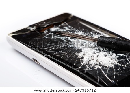 Smartphone with cracked display and screwdriver