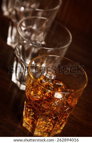 Glasses with whiskey on wooden bar counter