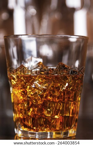 Glass  with whiskey on wooden bar counter
