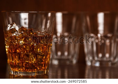 Glasses with whiskey on wooden bar counter