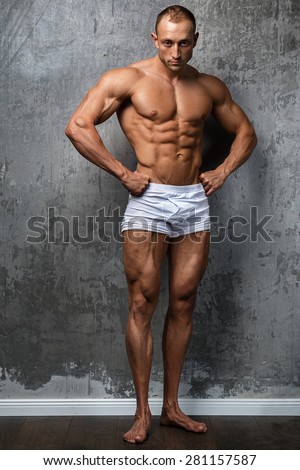 Sexy and muscular man  posing against stone wall