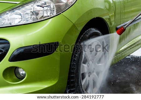 Green car in a hand car wash