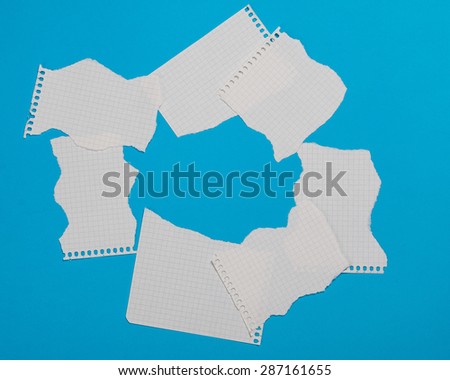 Torn pieces of checkered paper on blue background
