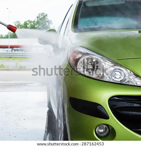 Green modern automobile in the car wash