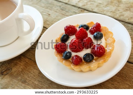 Delicious cake with berries and cup of coffee