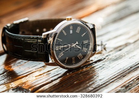 Expensive wrist watch on wooden surface