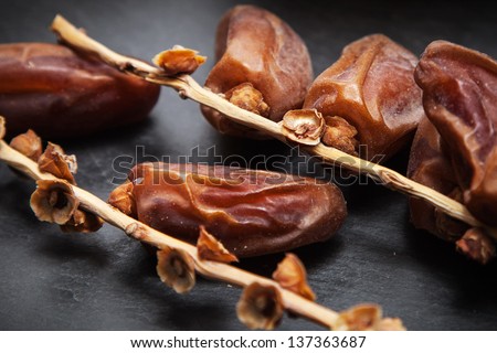 dried dates on vine resting on a dark gray slate board