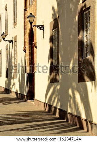 Colonial building with shadows of palm trees in old town of Las Palmas de Gran Canaria