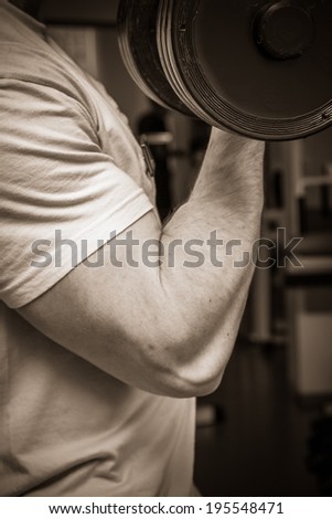 Man training with dumbbells in the gym.Black and white