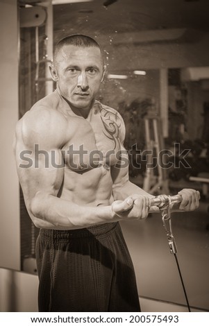 Man with tattoo in the gym.Sepia