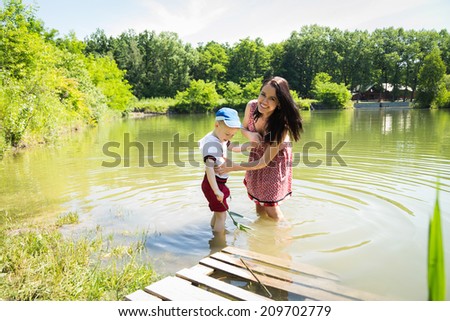 Mother and son on the lake. Standing knee-deep in water, cool in hot weather and communicate with each other.Nature, lake, swimming, baby - The concept of country vacation. article about the rest.