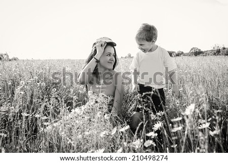 Mom and son in the summer field. Mother playing with her son in the catch-up. Mother and son having a great weekend. Games, field, family weekend - family-friendly concept. Article about the family.