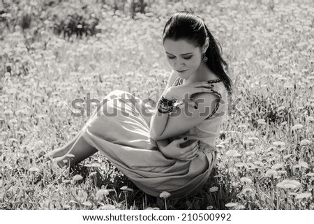 Black and white. Beautiful brunette in a lush spring garden. Girl enjoying flowering trees. Garden, beauty, flowers, - concept of enjoying nature. Idea of the article about the garden and nature.