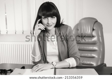 Black and white.Woman in a business suit. Business woman sitting at the table, working with the computer. Business, work, business woman - business concept girl. The idea about the woman\'s business.