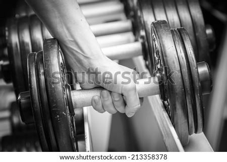 Muscular arm in the gym. in suspense. Training, sports, hand, dumbbell, trainnings. - The concept of a healthy lifestyle and fitness. article about fitness and sports.