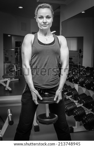 Girl at the gym. Hand holding a dumbbell. Girl doing exercises with dumbbell. Sports, fitness, dumbbell, gym - Concept of force, sport, health. Article about bodybuilding.