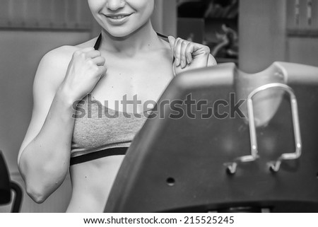 The beautiful blonde in the gym. The coach stands on the track simulator. Girl shows exercise. Treadmill, fitness, running, healthy living, trainnings - The concept of health. Article about the sport.