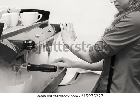 Female bartender in the workplace. Girl makes coffee using coffee machine. Coffee, cappuccino, coffee, coffee shop, the bartender - the concept of catering. Use in articles about coffee.