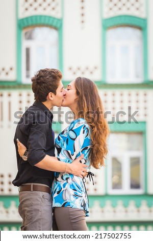 Attractive young couple kissing in a classic architecture city during their vacation. Young couple in love, hugging on the street.Happy young couple kissing on the city street.