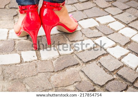 woman legs in red high heel shoes outdoor shot on cobble street