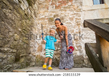 A family trip to a medieval castle. Mom and son on the stairs of a medieval fortress. Travel, family, stairs, family holiday - Travel Concept