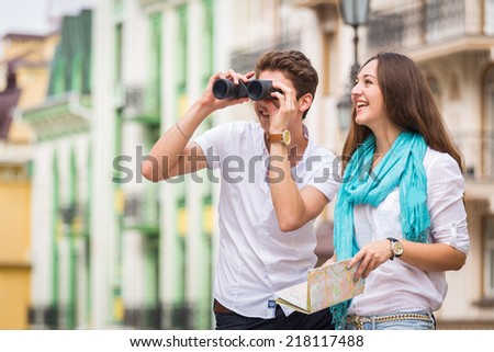 Girl and guy on the streets of European cities. Couple walking along the picturesque street. They look at the sights. Travel, couple, city, map, beauty, walk - travel concept. Article about Travel