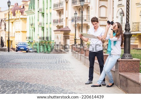 Girl and guy on the streets of European cities. Couple walking along the picturesque street. They look at the sights. Travel, couple, city, map, beauty, walk - travel concept. Article about Travel