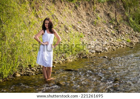 Beautiful woman at the river. Young woman goes barefoot through the mountain river in sunny weather.Enjoyment. Free Happy Woman Enjoying Nature. Beauty Girl Outdoor. Freedom concept