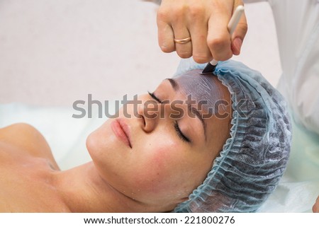 Pretty woman receiving facial treatment. Cosmetology, facial, beauty - The concept of facial skin care. Article about cosmetology.
