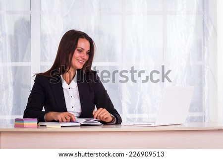 Young pretty business woman with notebook in the office.