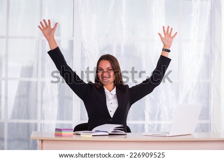 Young pretty business woman with notebook in the office.Successful business woman with arms up - isolated over a white background