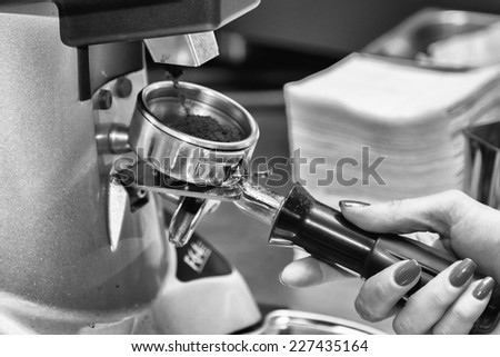 Female bartender in the workplace. Girl makes coffee using coffee machine. Coffee, cappuccino, coffee, coffee shop, the bartender - the concept of catering. Use in articles about coffee.