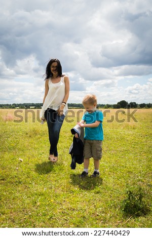 Mom and son in the summer field. Mother playing with her son. Mother and son having a great weekend. Games, field, family weekend - family-friendly concept. Article about the family.