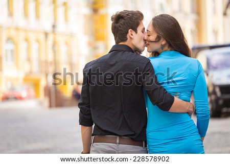 Young couple in love traveling around the beautiful city. Young people hugging and kissing on the streets.Young couple in love, hugging on the street.Happy young couple kissing on the city street.